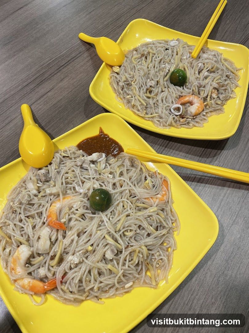 Two plates of noodles with shrimp and squid