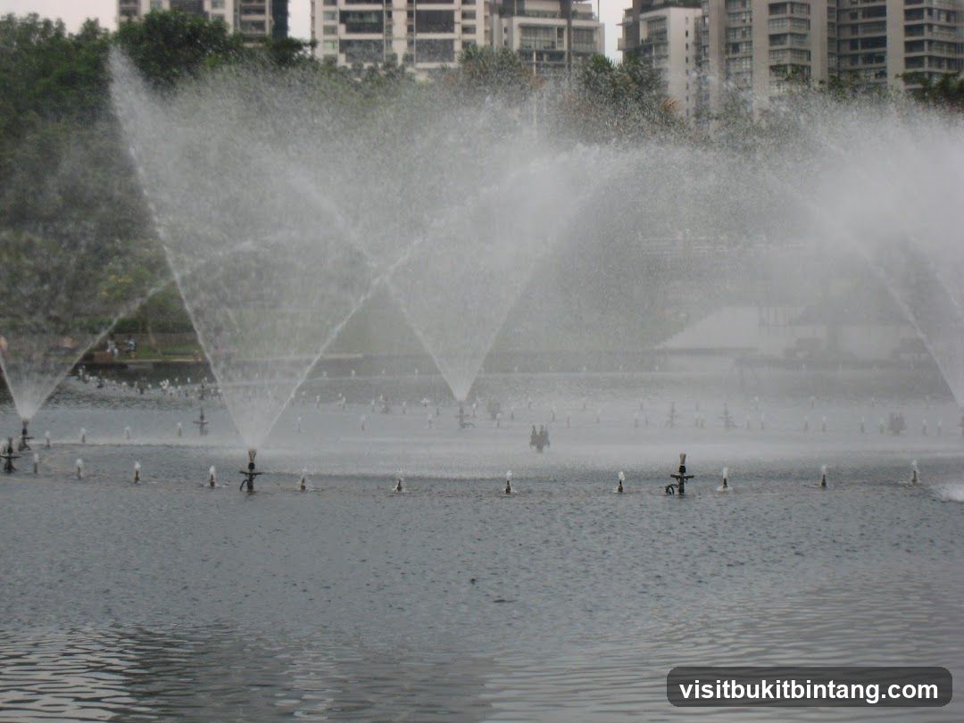 Fountain display with city buildings in the background
