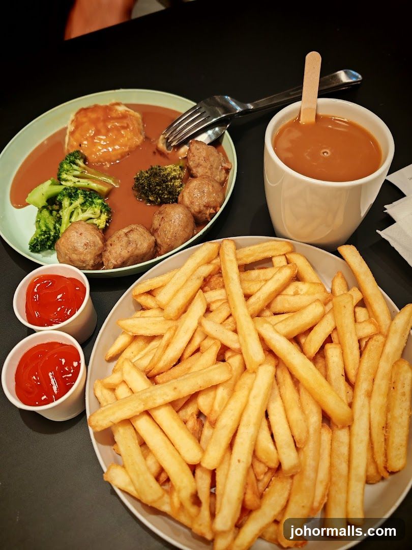 Meatballs with mashed potatoes, broccoli, fries, and a drink