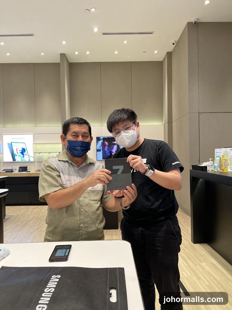 Two men holding a Samsung product box