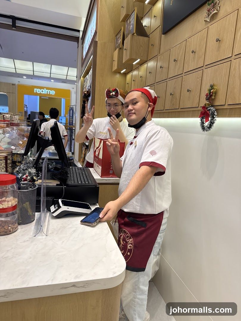 Two employees in festive hats at a counter