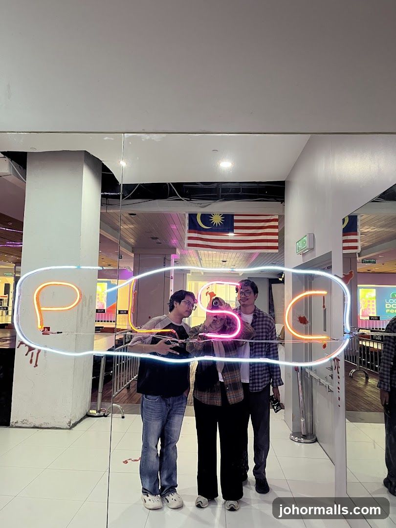 People posing in front of a neon sign