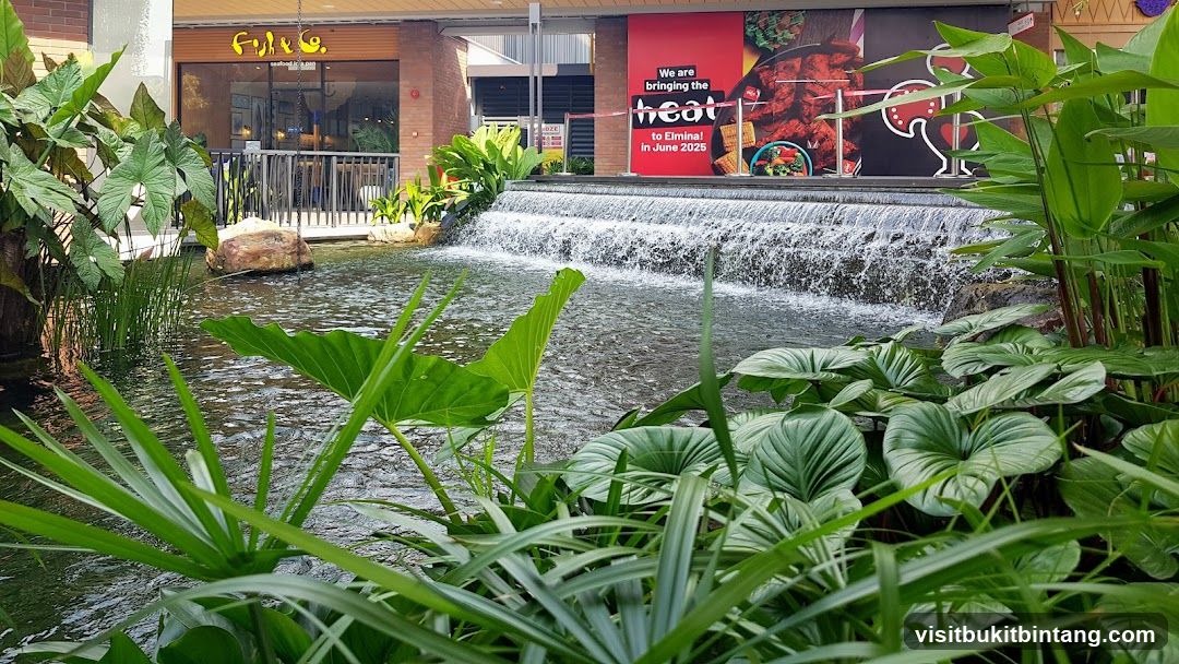 Outdoor seating area with a waterfall and lush greenery
