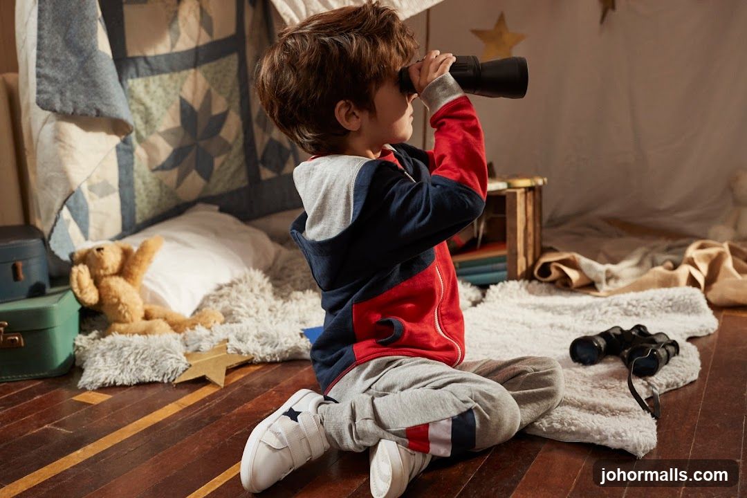 Boy with binoculars in a tent