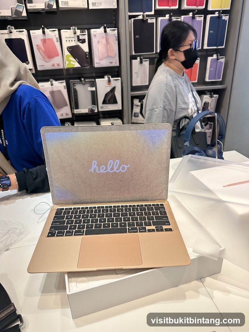 Gold MacBook Air with "hello" on screen