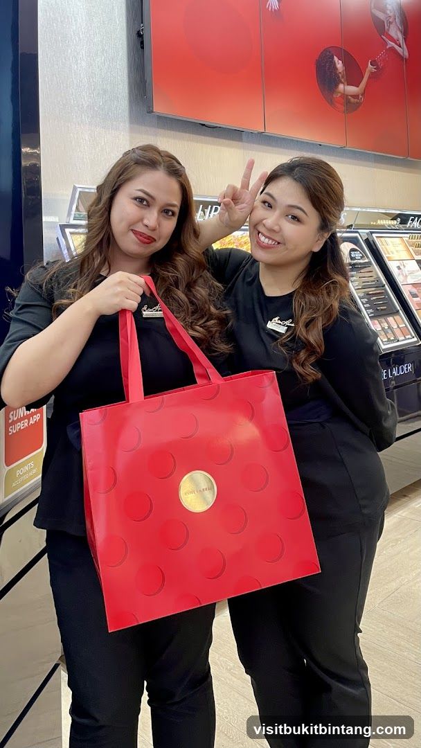 Two women holding a red bag