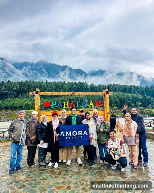 Group posing with a flag in front of a scenic backdrop
