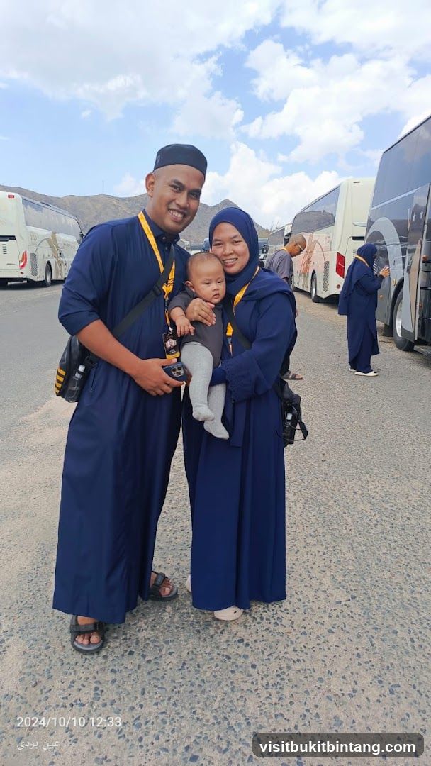 Family posing with buses in the background