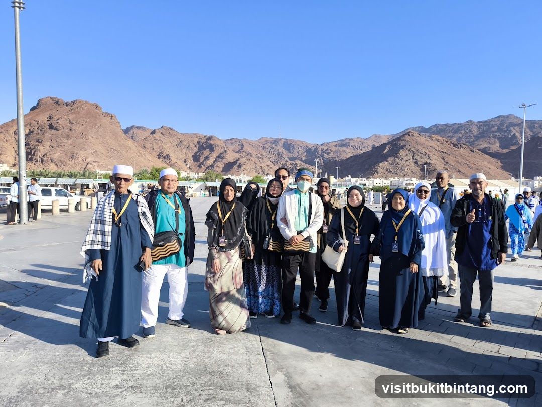 Group of people in traditional attire with mountains in the background