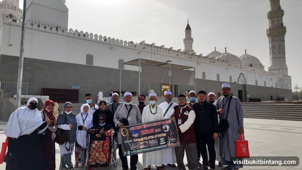 Group posing with Umrah banner