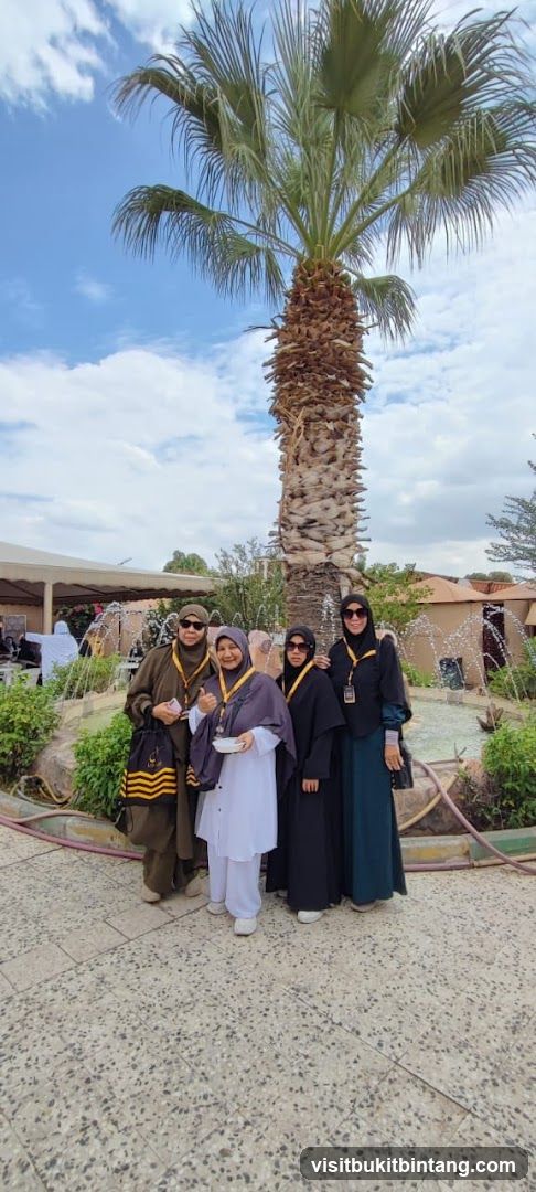 Four women posing under a palm tree