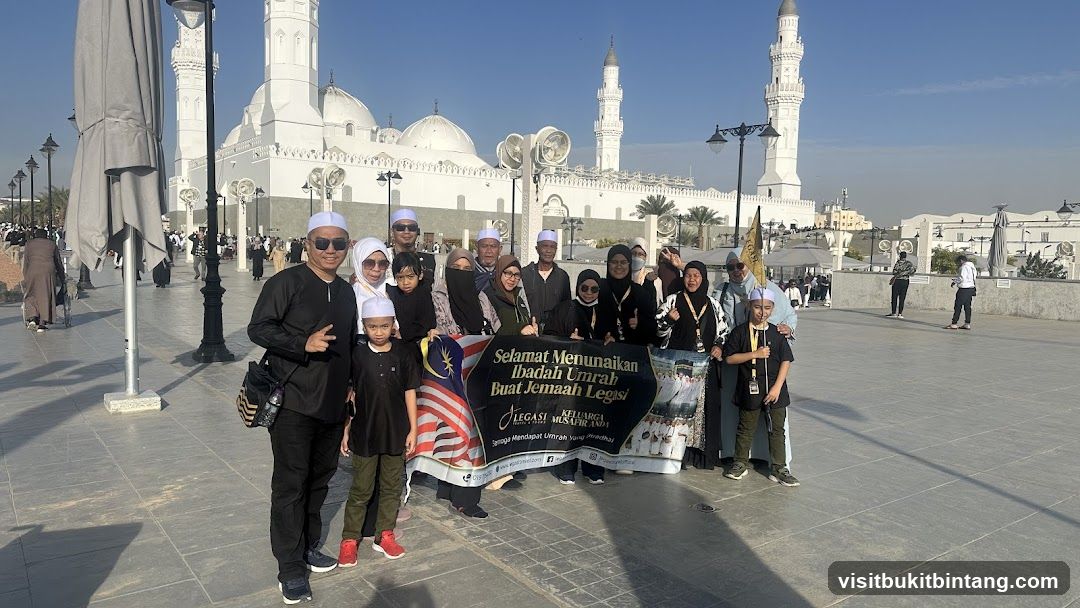 Group Posing with Banner in Front of Mosque