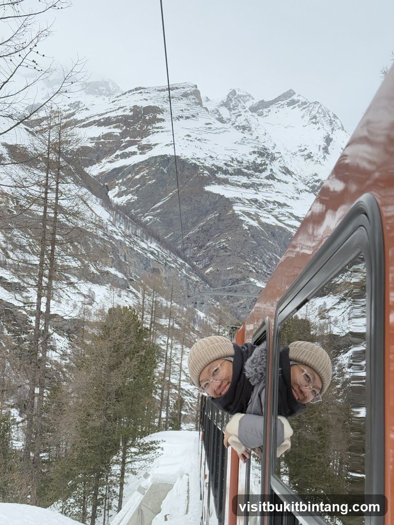 People looking out of train window in snowy mountains