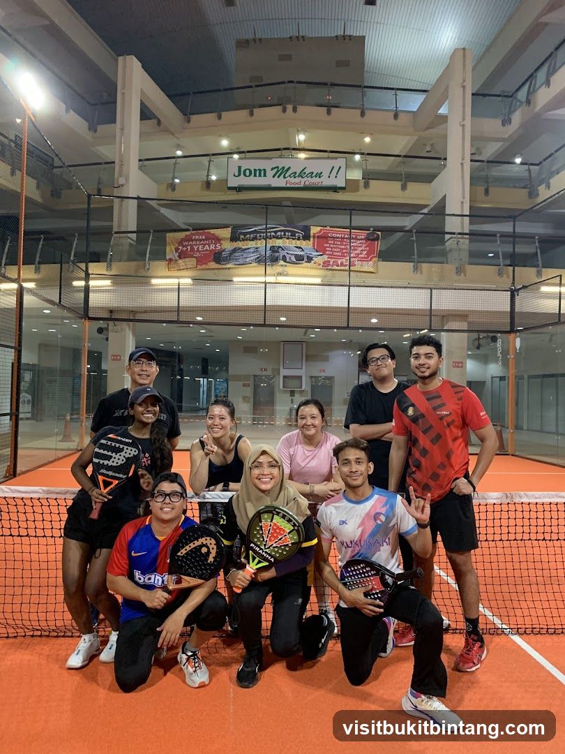 Group of people posing with paddles on a court