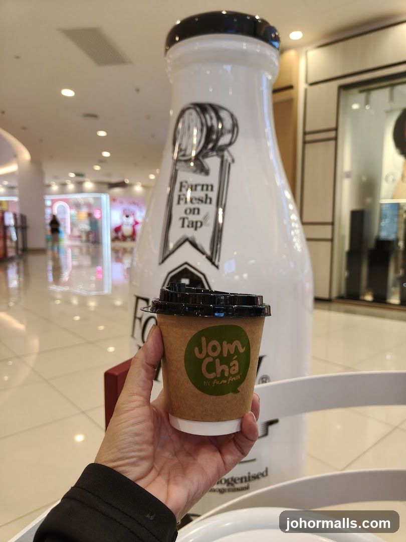 Person holding a cup of Jom Cha
