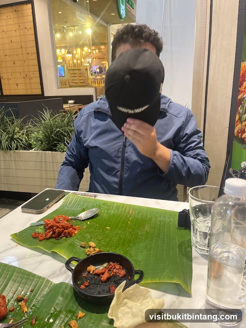 Person hiding face with cap at table with food