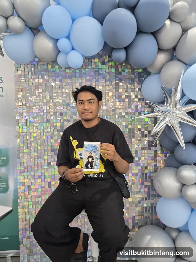Man holding a photo in front of a balloon arch