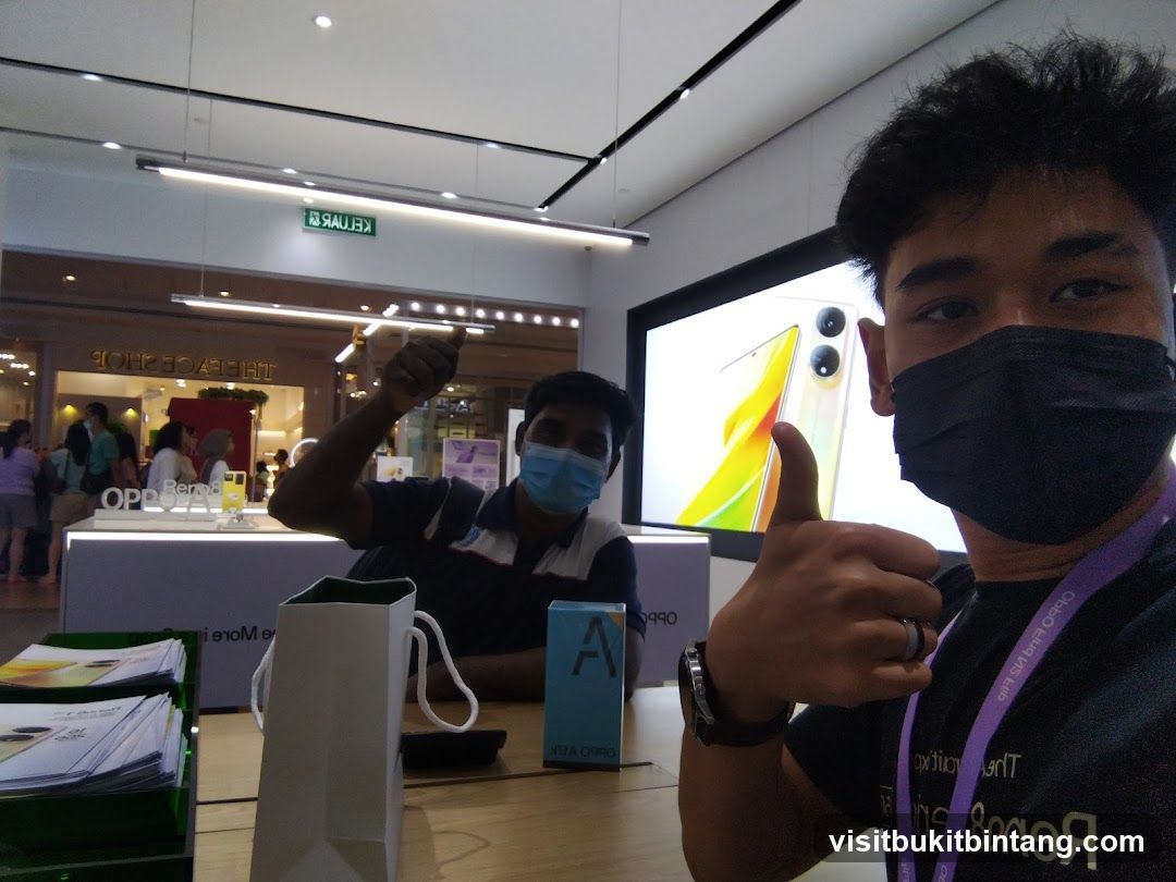Two men giving thumbs up in an electronics store