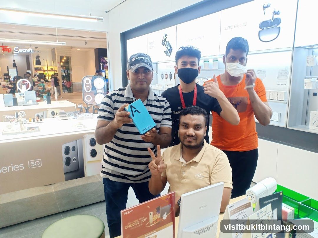 Four men posing in an electronics store