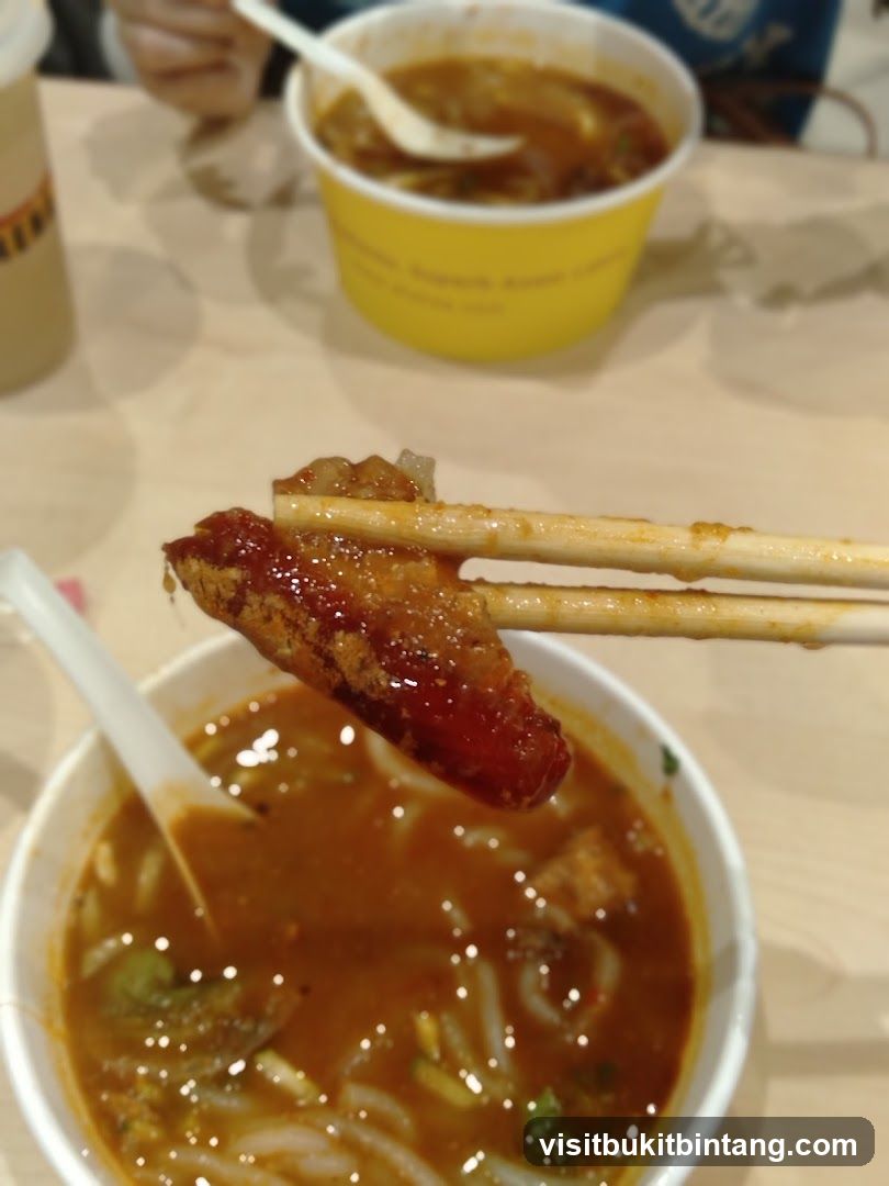 Close-up of a piece of food being held over a bowl of soup