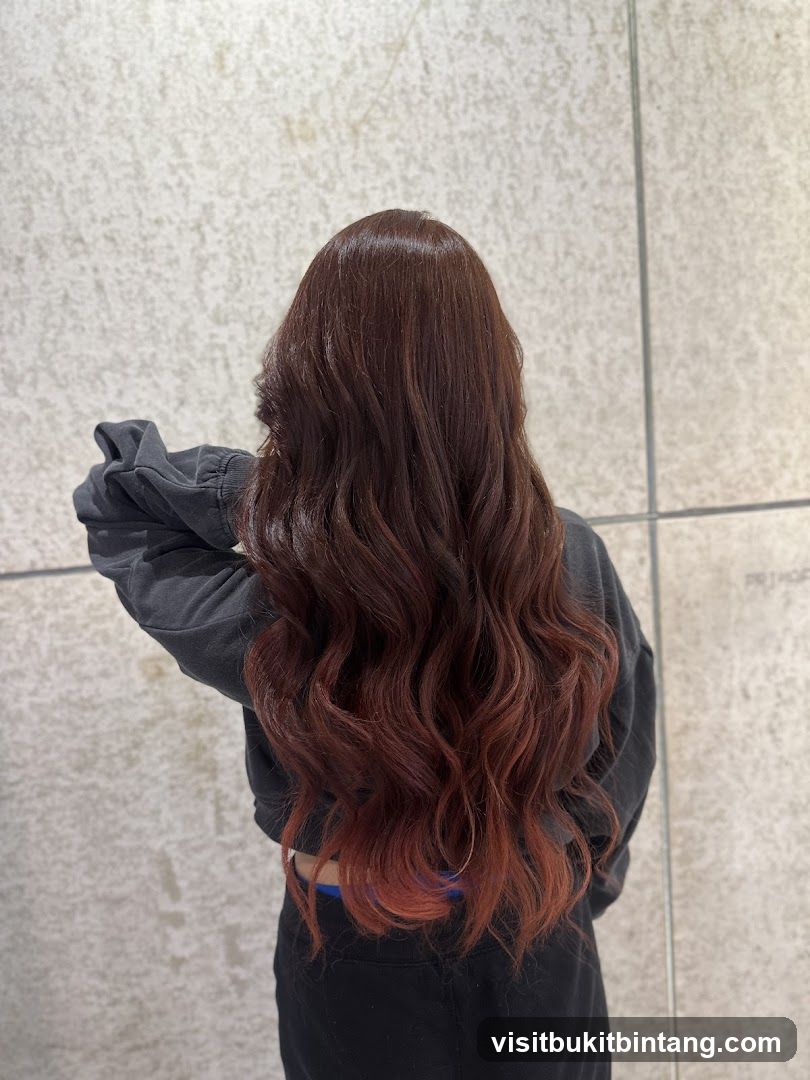 Woman with long, wavy, auburn-tinted hair