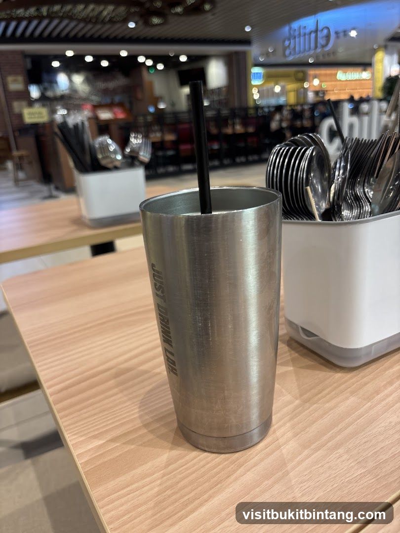 Metal Tumbler with Straw on Table