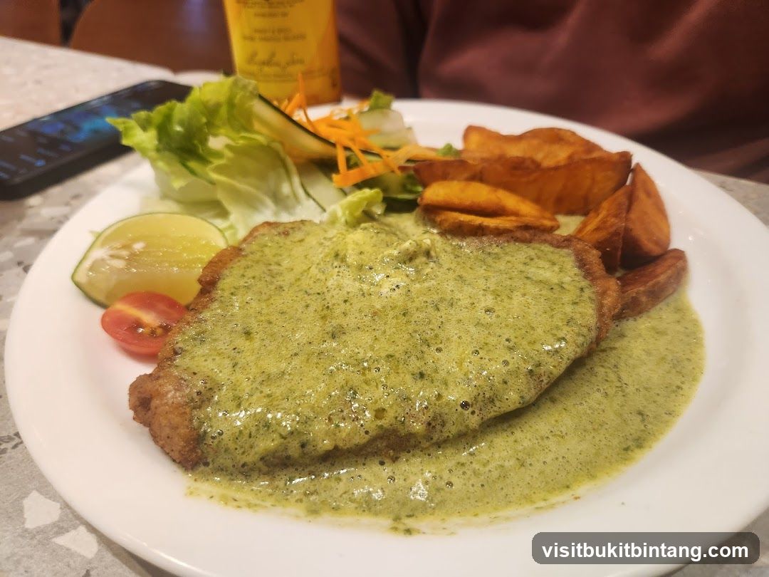 Breaded cutlet with green sauce and potato wedges