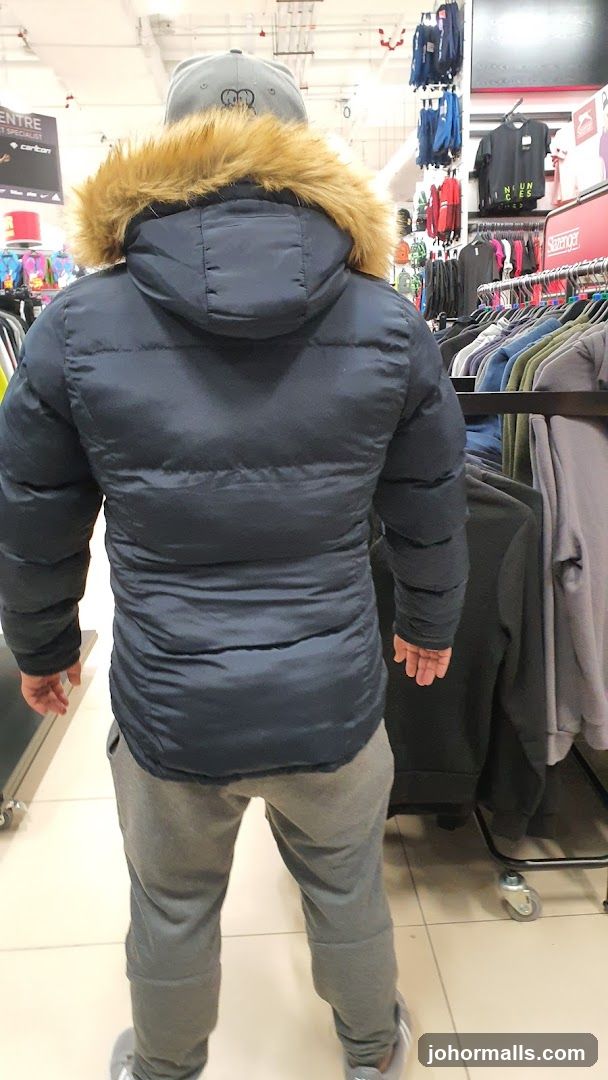 Man wearing a puffer jacket in a clothing store