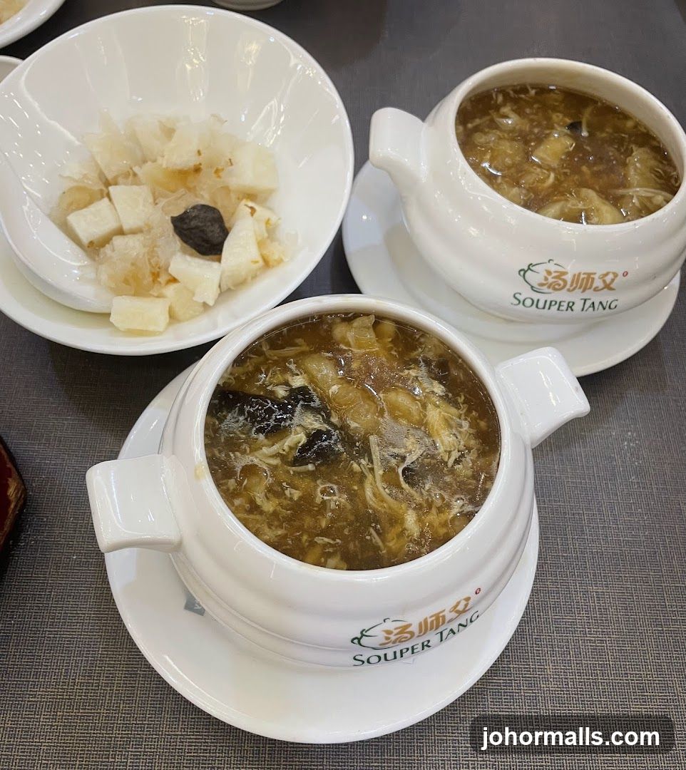 Two bowls of soup and a side dish