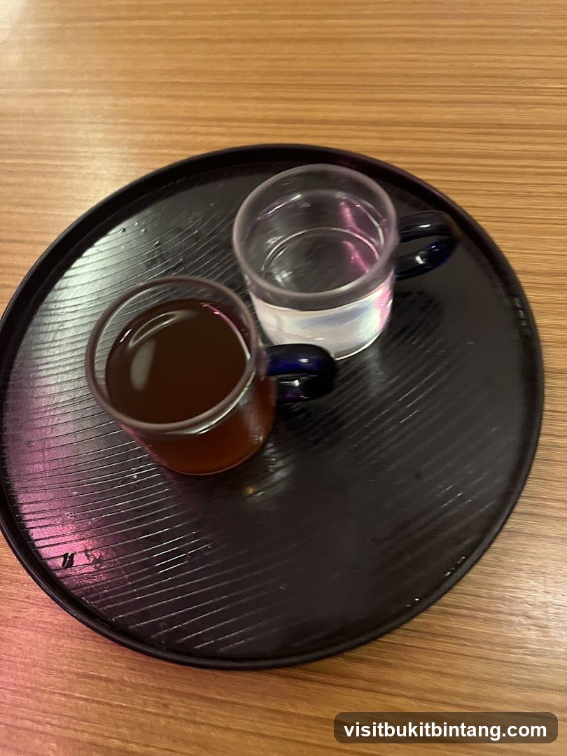 Two small glasses of drinks on a tray