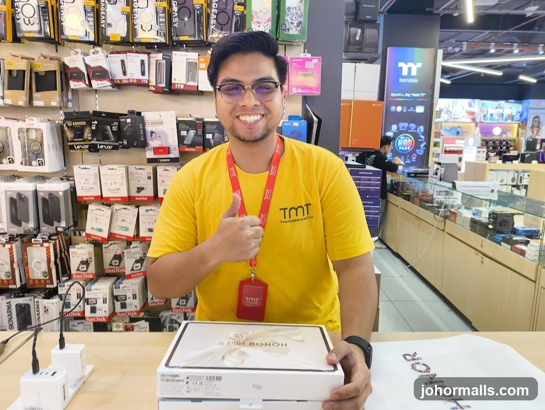 Man in a yellow shirt holding a box