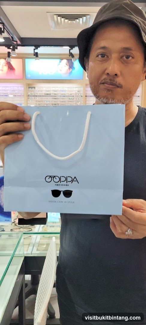 Man holding a shopping bag with glasses logo