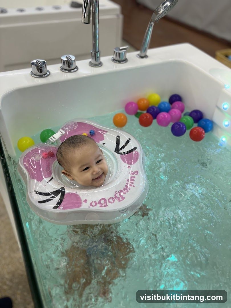 Baby enjoying a bath with colorful balls