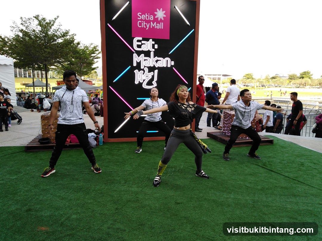 People dancing in front of a mall advertisement