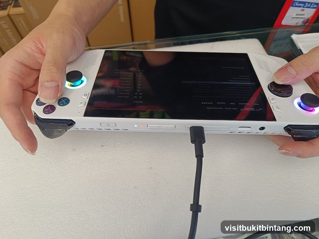 Hand holding a white gaming handheld device