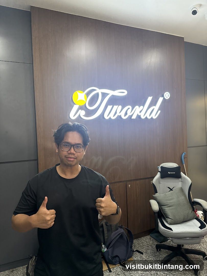 Man giving thumbs up in front of iTworld sign
