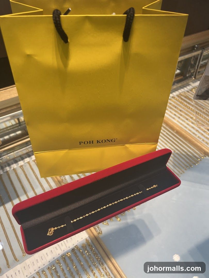 Gold bracelet in a red case with a yellow shopping bag