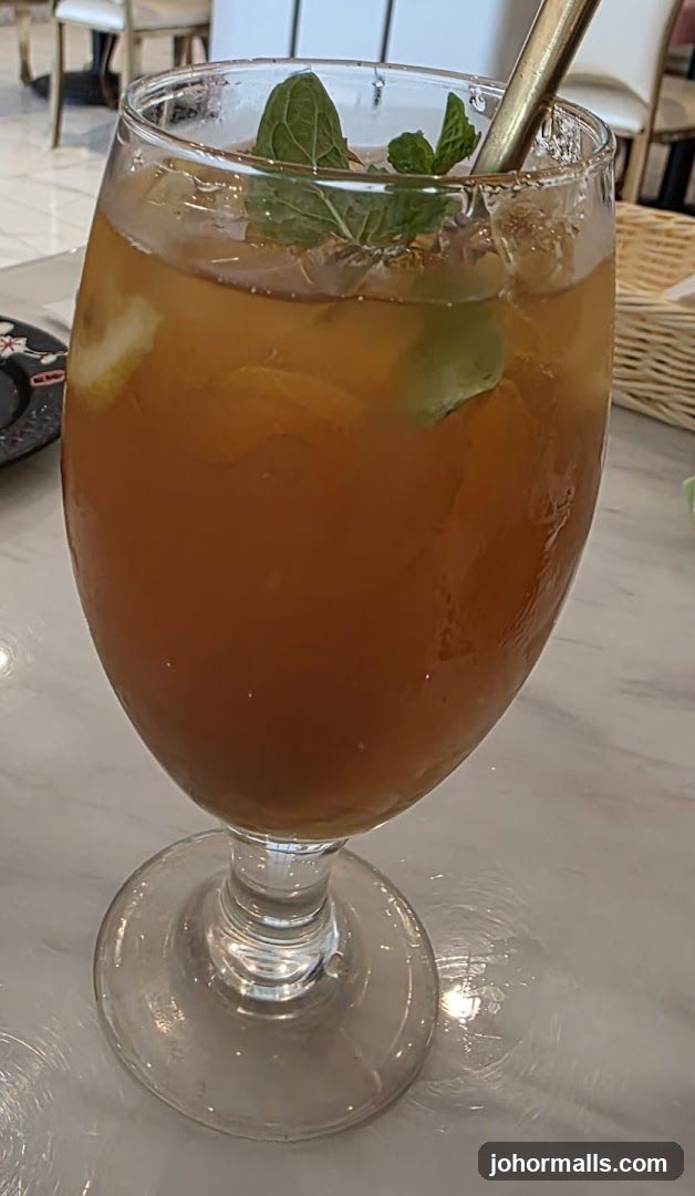 Iced beverage in glass with mint garnish