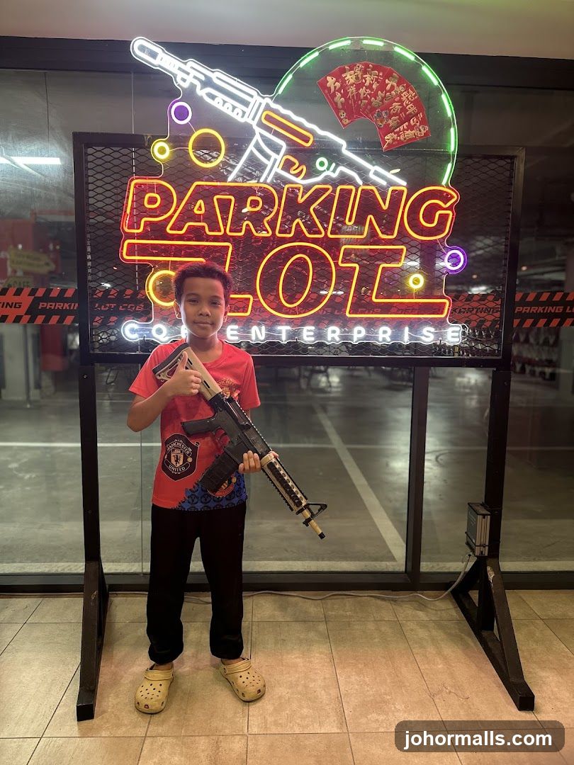 Boy with toy gun in front of neon sign