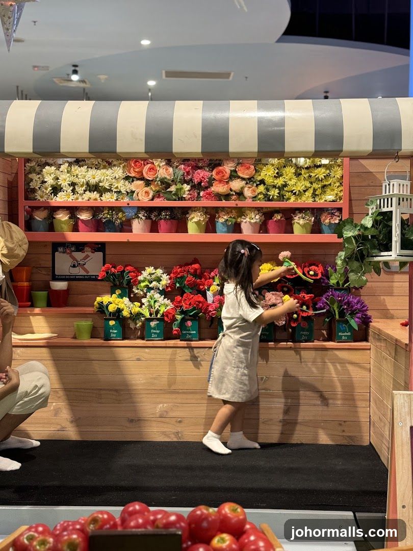 Child arranging flowers at a stall