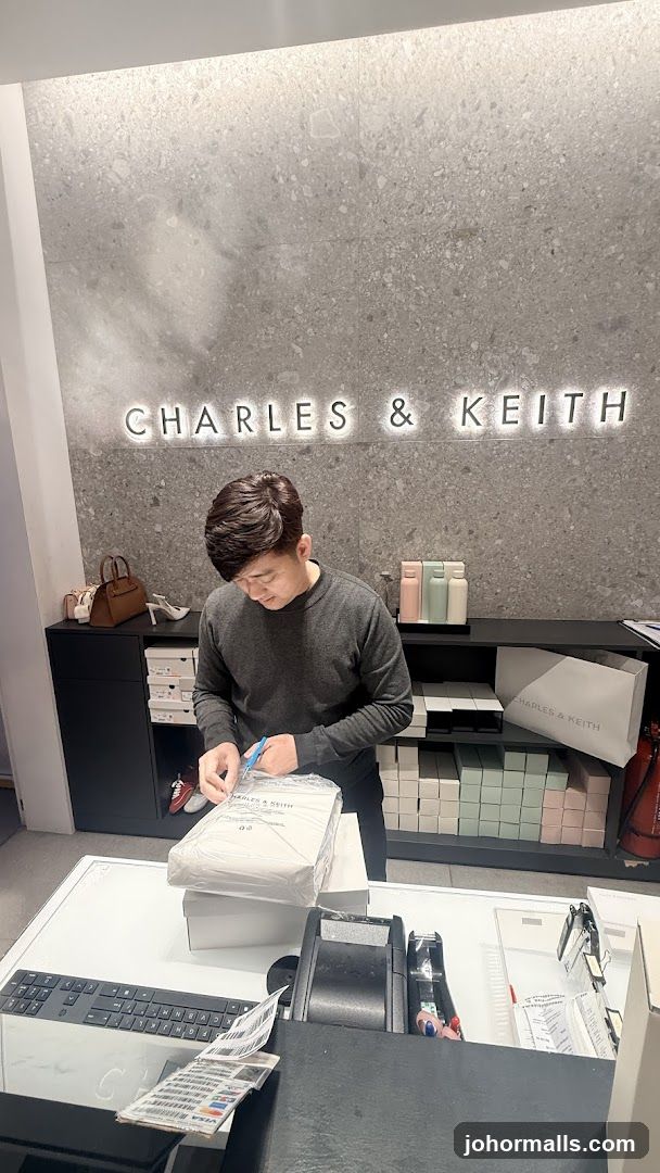Employee preparing a package at Charles & Keith store