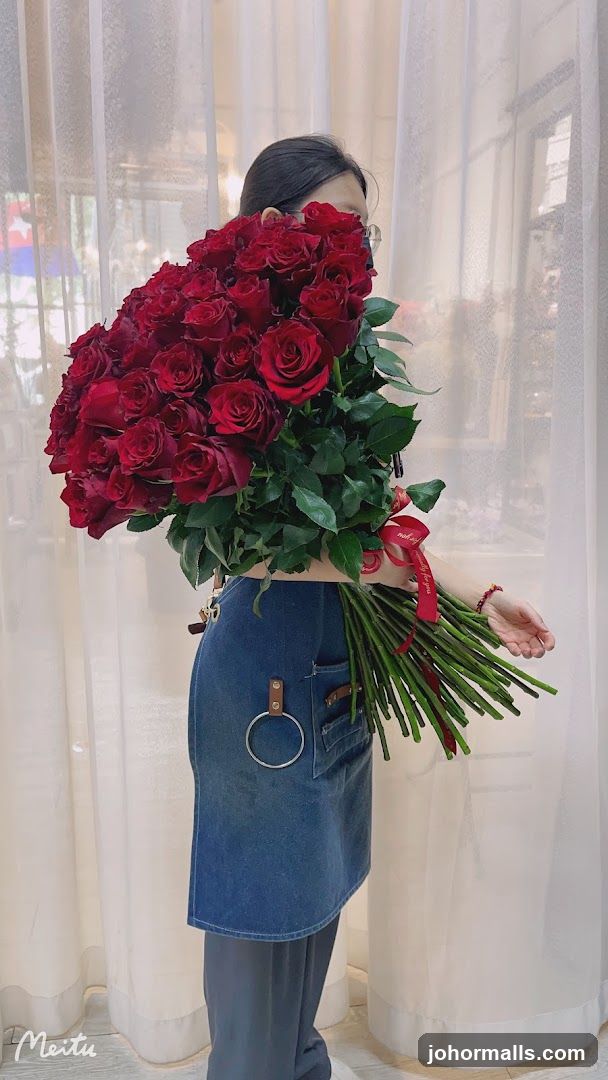 Woman Holding a Large Bouquet of Red Roses