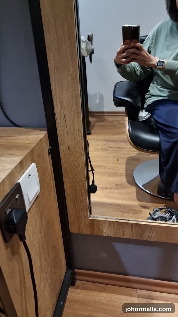 Person taking a mirror selfie in a salon chair