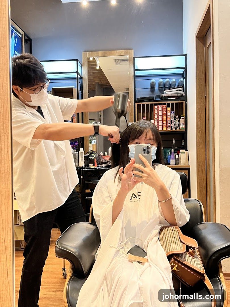 Hairdresser drying client's hair