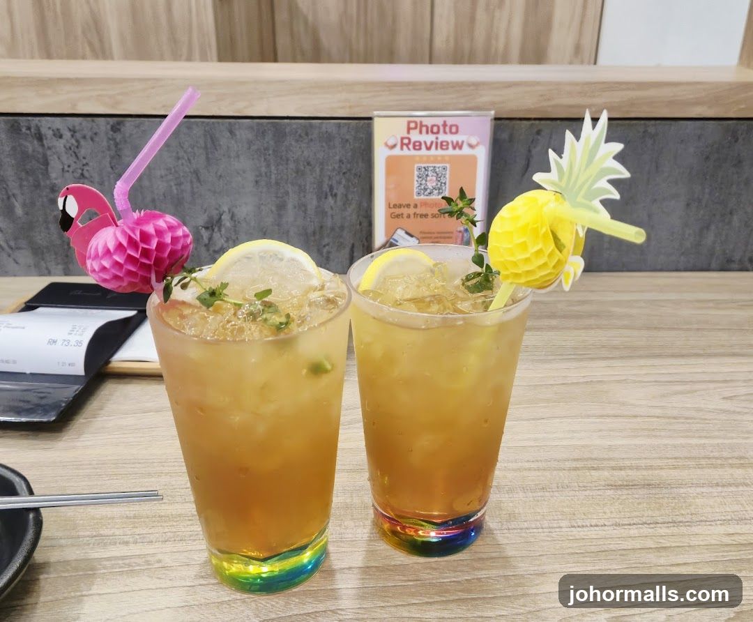 Two iced drinks with fruit garnishes
