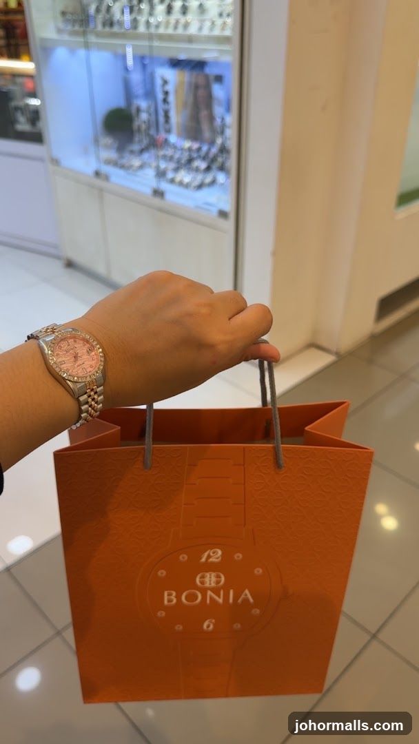 Person holding a Bonia shopping bag and wearing a Bonia watch