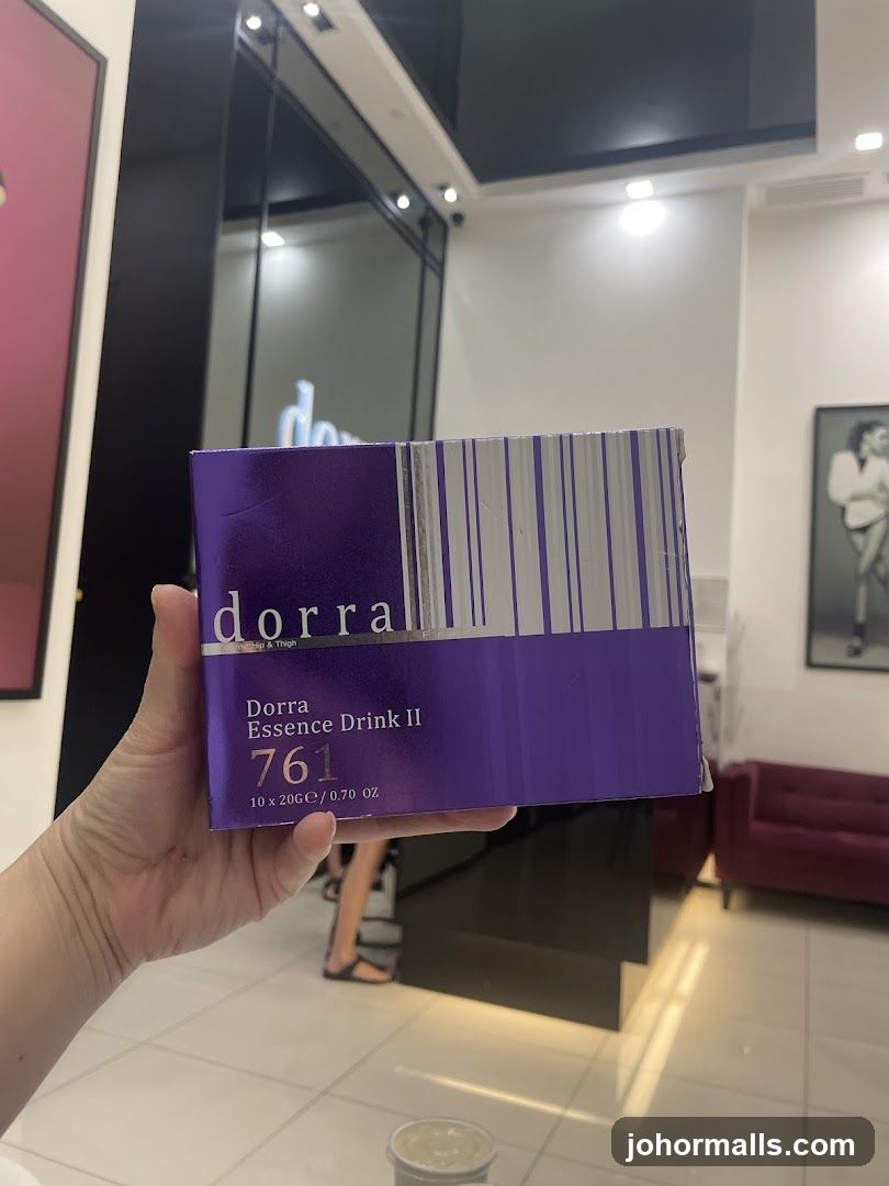 Hand holding Dorra Essence Drink II box