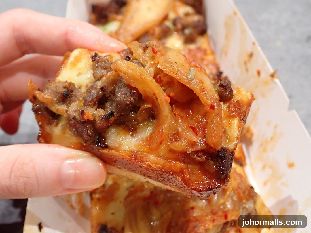 Close-up of a slice of pizza with meat and kimchi