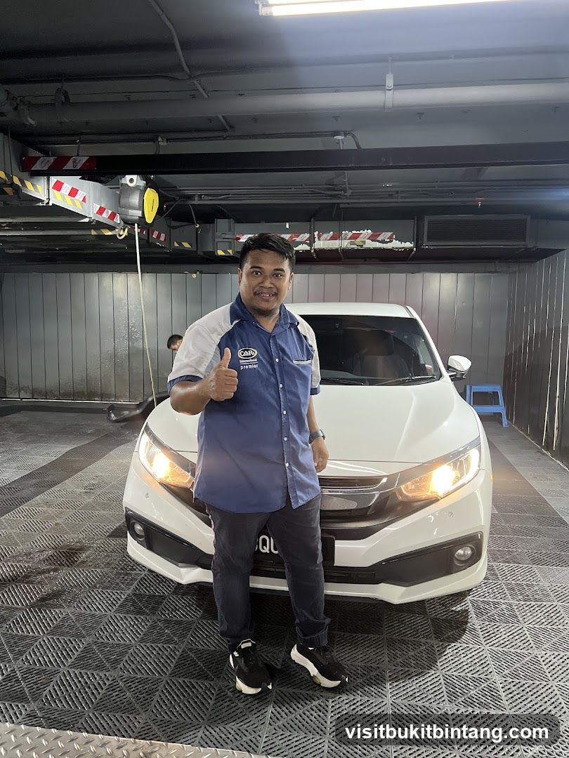 Man giving thumbs up next to a white car