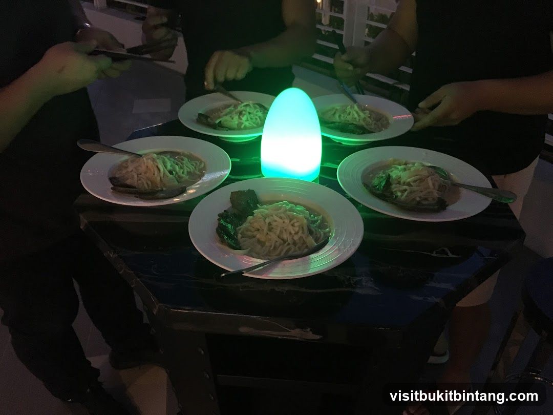 People gathered around a table with bowls of noodles